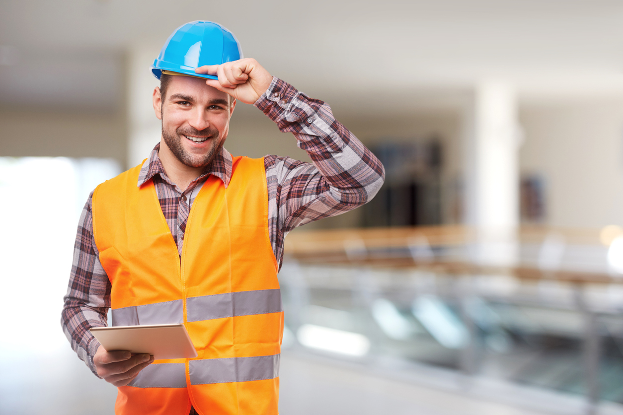 Manual worker in blue helmet with digital tablet
